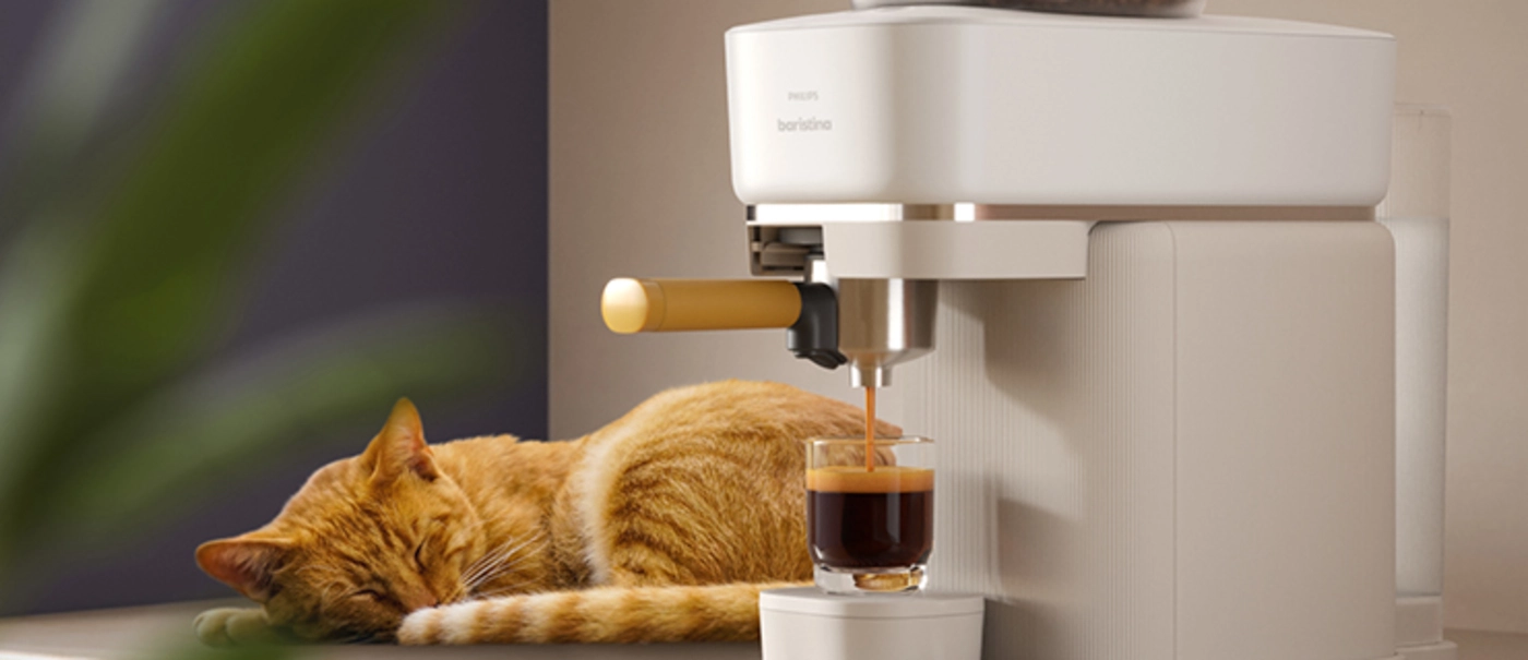 Katze schläft neben der Baristina-Expressomaschine und macht einen Kaffee