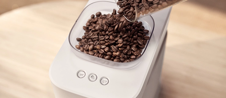 The process of inserting beans into the Baristina espresso machine